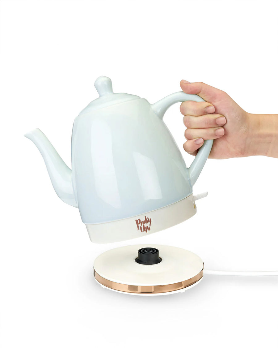 model lifting mint ceramic electric tea kettle off of rose gold base