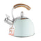 mint 70 oz classic whistling tea kettle with wooden handle with pinky's up tag on it