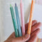 model holding set of 4 various reading theme colored pens