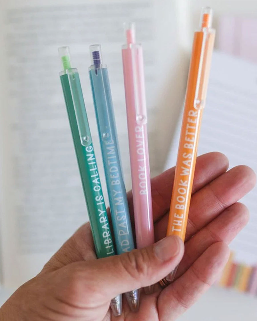 model holding set of 4 various reading theme colored pens