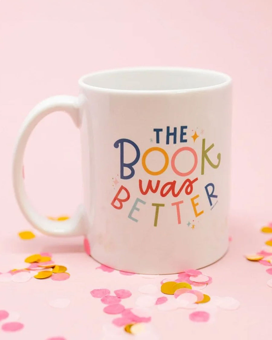 white ceramic mug with colorful 'the book was better' across the front surrounded by confetti