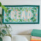 7 in. x 14 in. rectangular embroidered wall hanging with 'read' across the front displayed on a wall