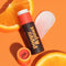 lemon and orange scented lip balm next to orange slices