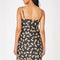 back view of model wearing black mini dress with yellow bow tie pasta print and yellow ribbon on the straps