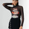 model wearing black sheer long sleeve top with turtleneck and seafood tower graphics