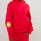 model wearing red hoodie with yellow smiley print on sleeves