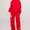 model wearing red sweatpants with yellow smiley print on legs