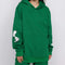 model wearing kelly green hoodie with woodstock and snoopy print on sleeves