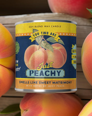 'just peachy' peach scented candle on table surrounded by peaches