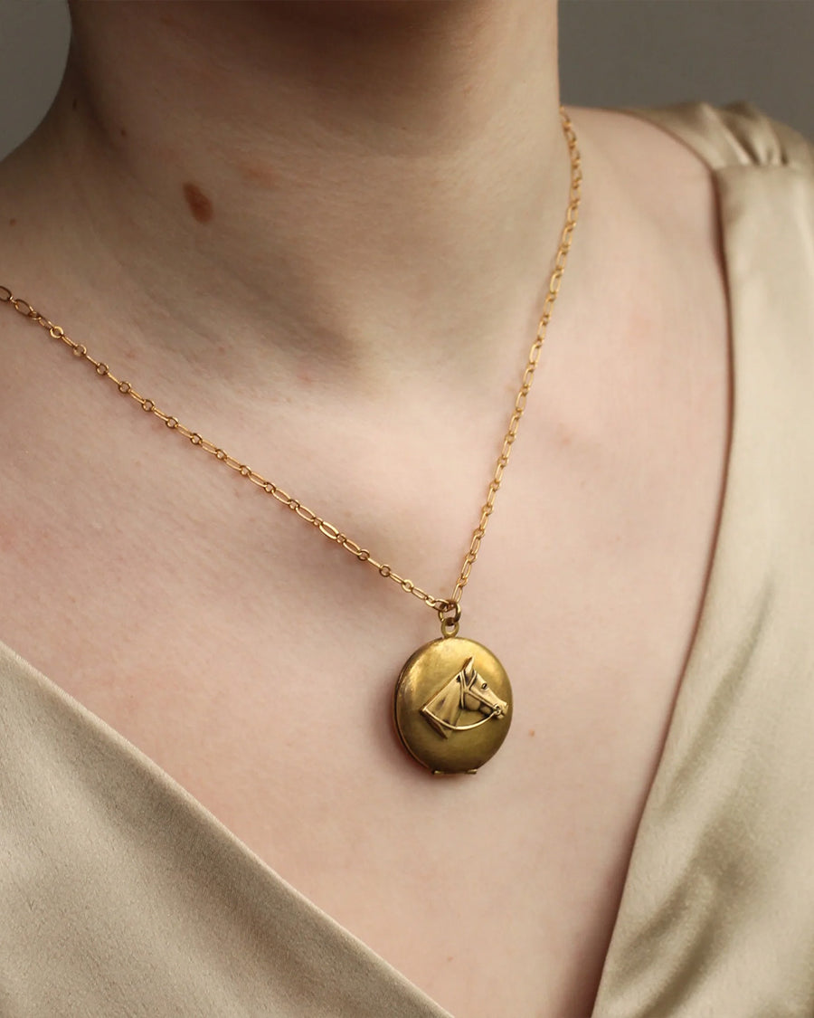 model wearing brass horse head locket necklace