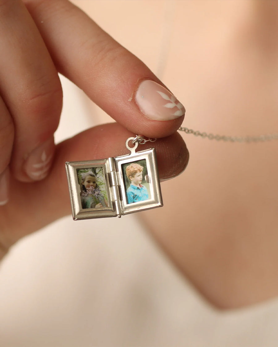 photos inside of silver book shaped locket