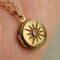 up close of gold tiny compass star locket