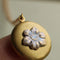 model holding brass forget me not flower locket necklace