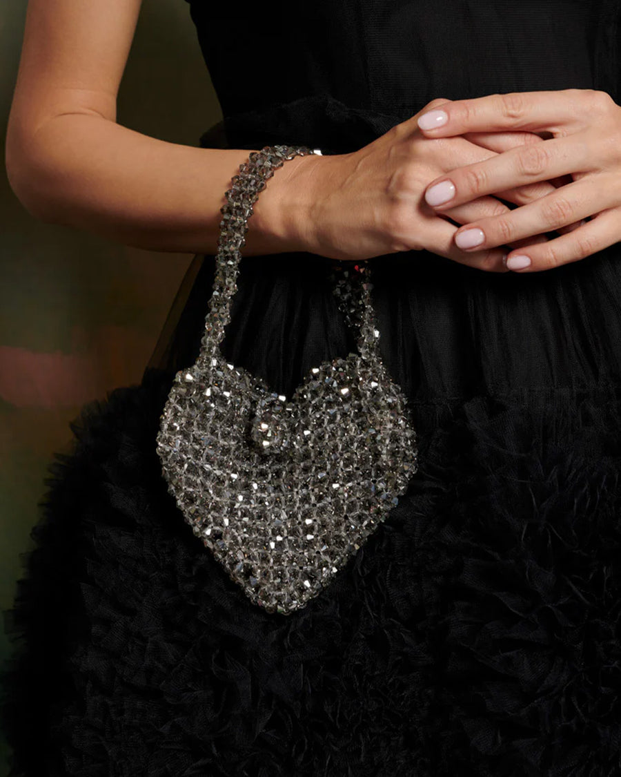 model wearing silver beaded heart shape bag