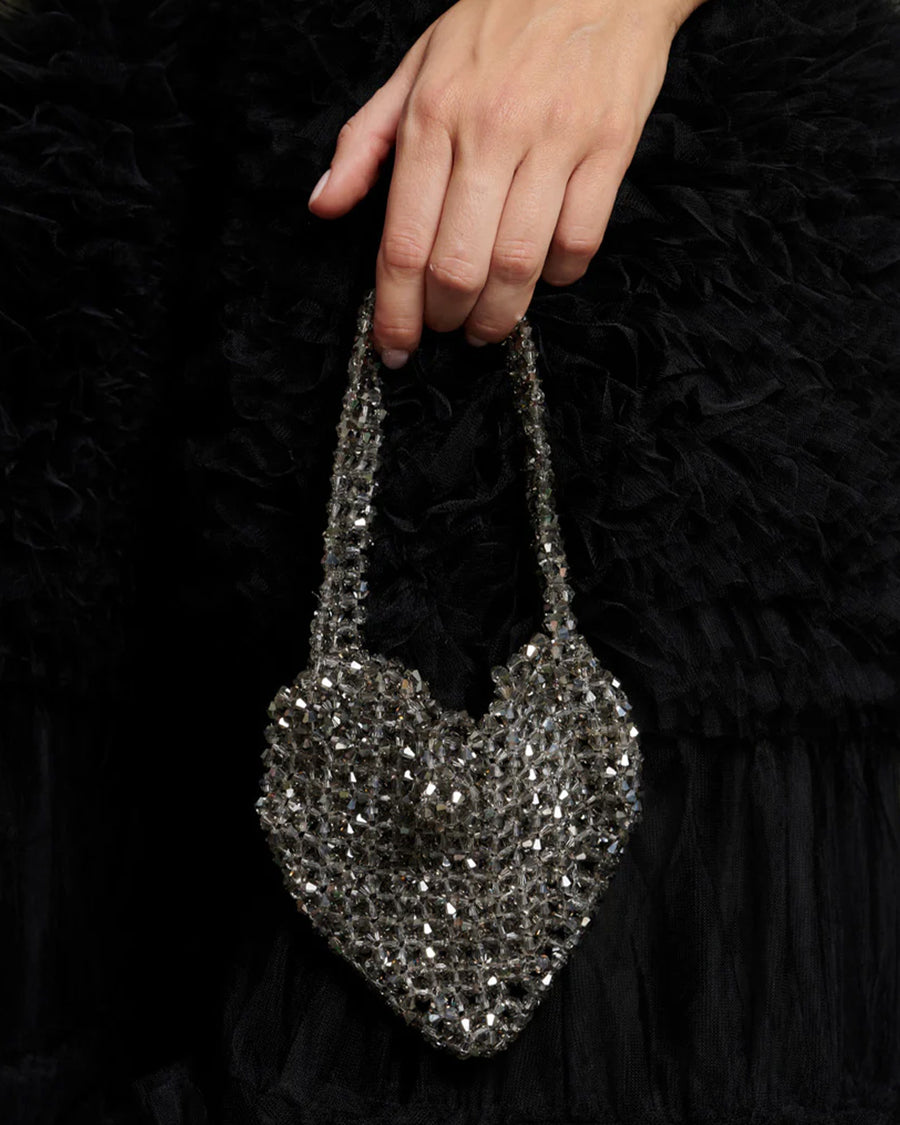 model wearing silver beaded heart shape bag