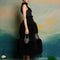 sideview of model wearing black tulle midi dress with tufted tulle layers