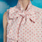 up close of model wearing light pink mini dress with all over pink heart print and oversized bow