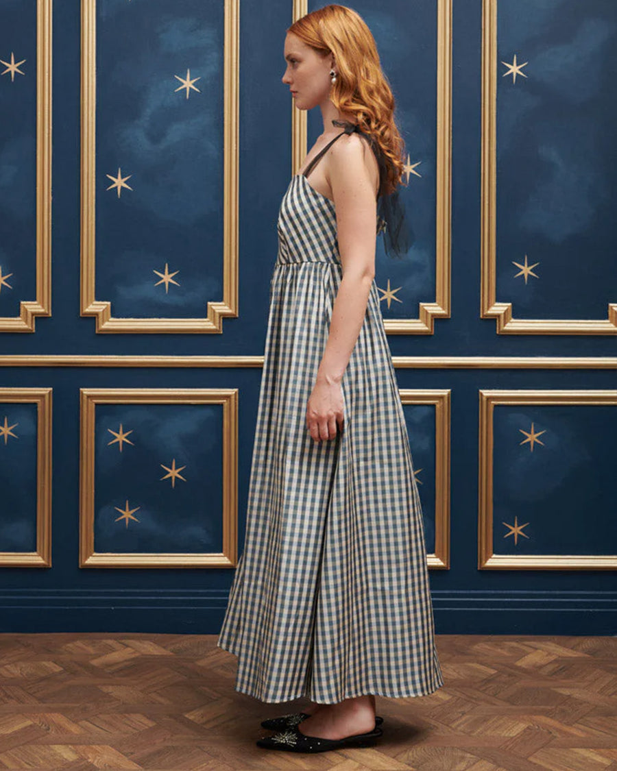 side view of model wearing blue and white checkered dress with tulle straps