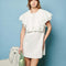 model wearing white mini dress with oversized ruffle cape top