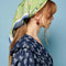 side view of model wearing green headscarf with all over dog print