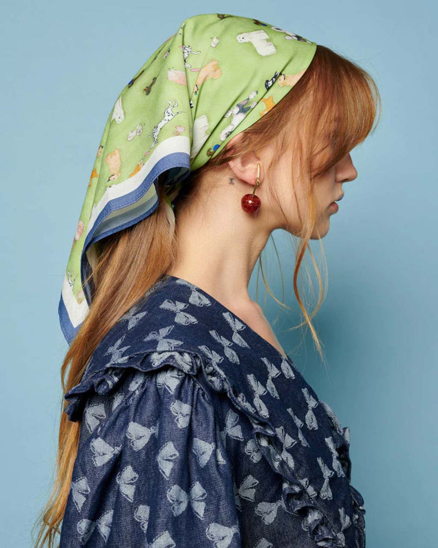 side view of model wearing green headscarf with all over dog print