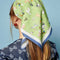 back view of model wearing green headscarf with all over dog print