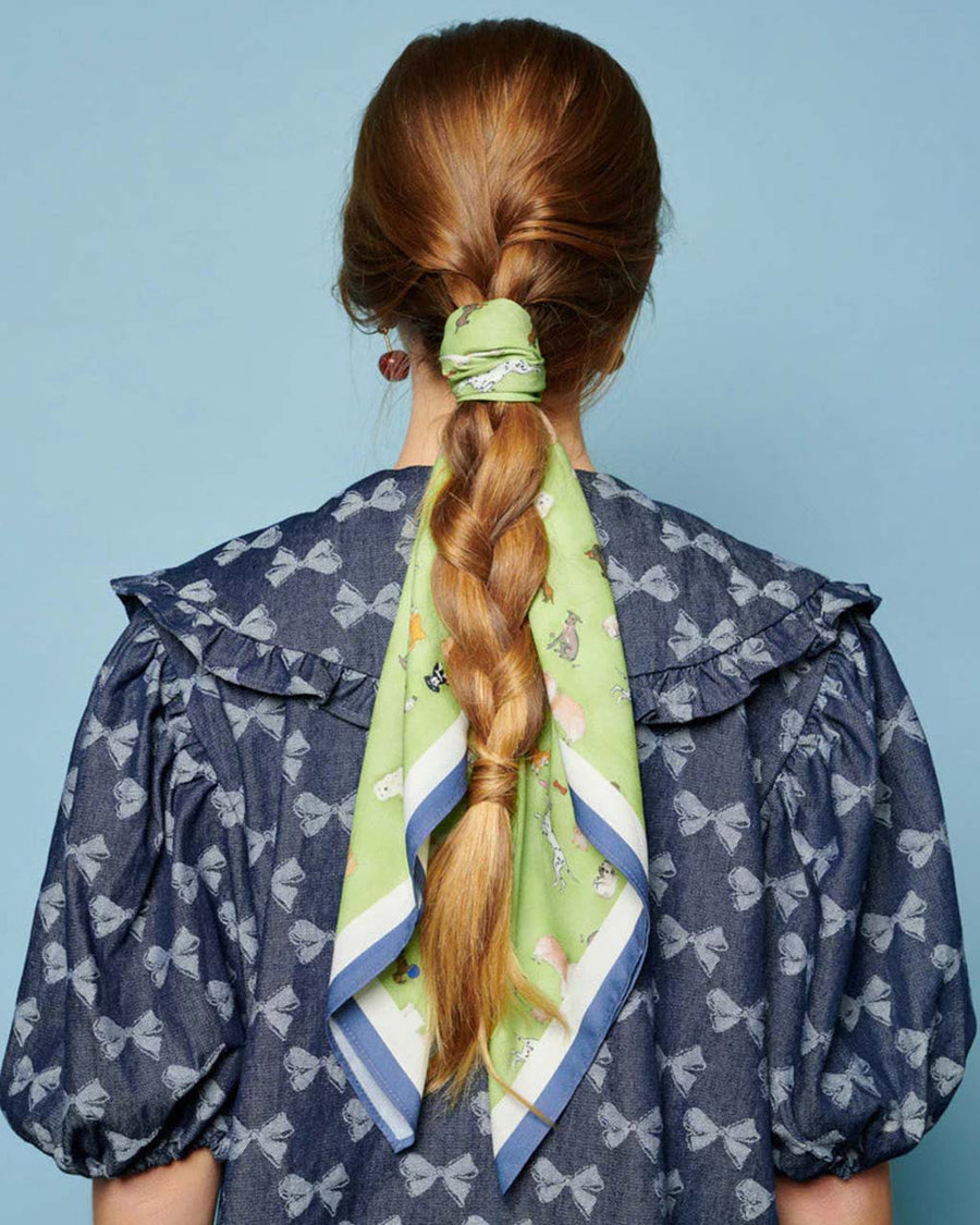 model wearing green headscarf with all over dog print wrapped around their braid