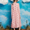 back view of model wearing light pink midi dress with long sleeves, front yoke and tie and pink cowboy hat print