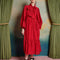 model wearing red midi dress with oversized tie neckline, slight puff long sleeves and tiered skirt