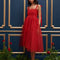 model wearing red tulle midi dress with velvet tie straps and smocked bodice