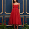 model wearing red tulle midi dress with velvet tie straps and smocked bodice