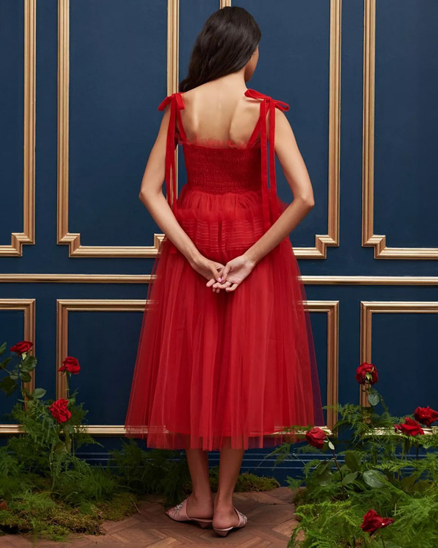 back view of model wearing red tulle midi dress with velvet tie straps and smocked bodice