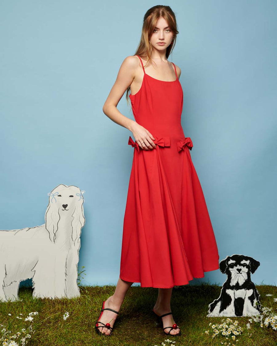 model wearing red midi dress with bows on the waist