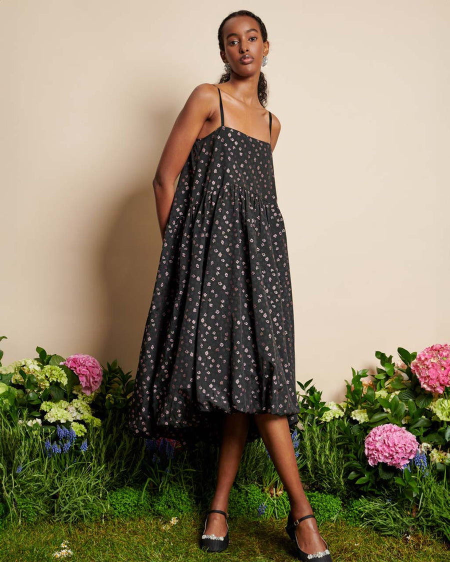 model wearing black bubble hem midi dress with delicate pink flowers and open back