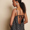 back view of model wearing black bubble hem midi dress with delicate pink flowers and open back