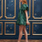 side view of model wearing emerald green jacquard mini dress with puff sleeves and bubble hem