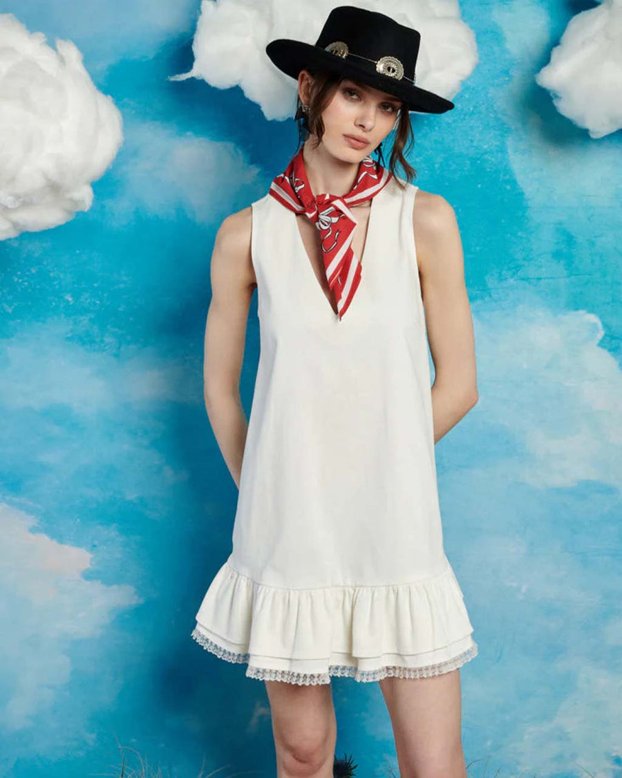 model wearing white mini dress with ruffle hem and deep v neckline