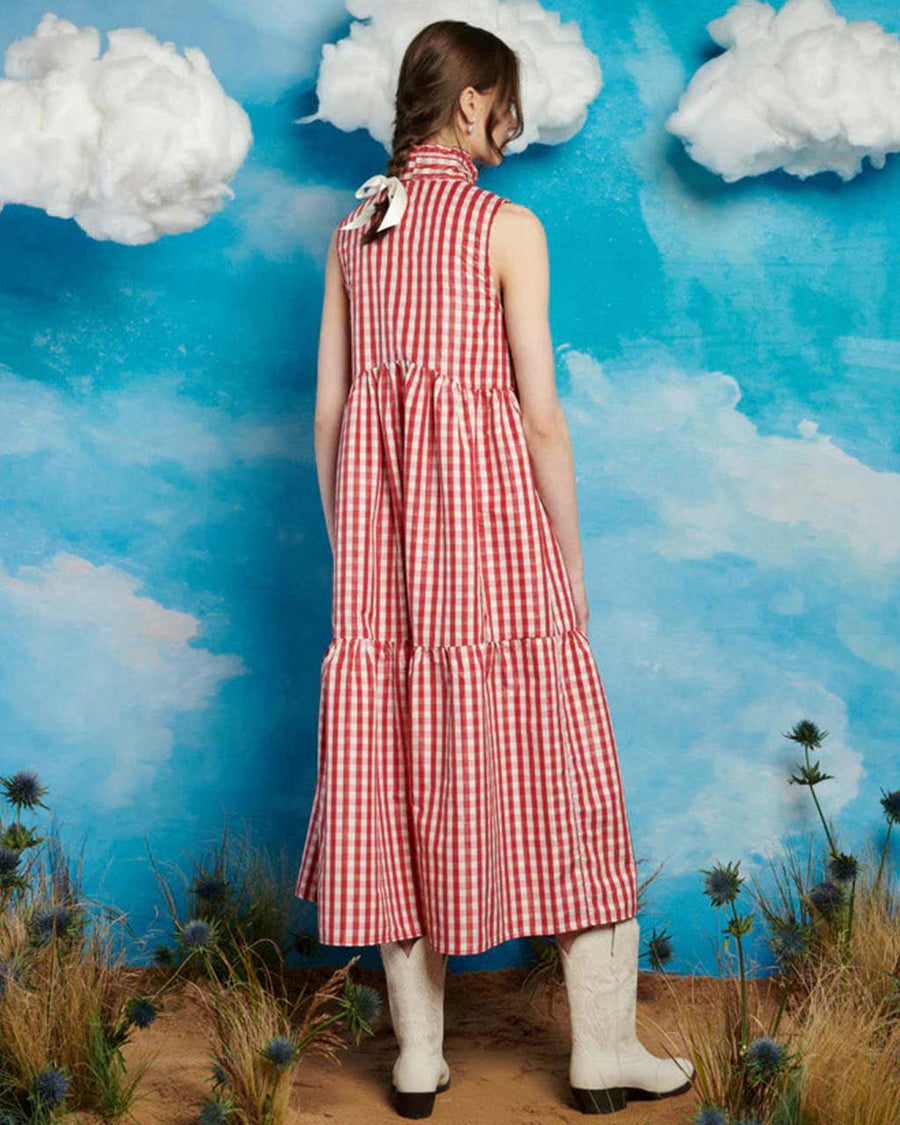 back view of model wearing red and white gingham maxi dress with tiered skirt and oversized bow