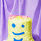 yellow trash bags with blue smiley face print filled with popcorn