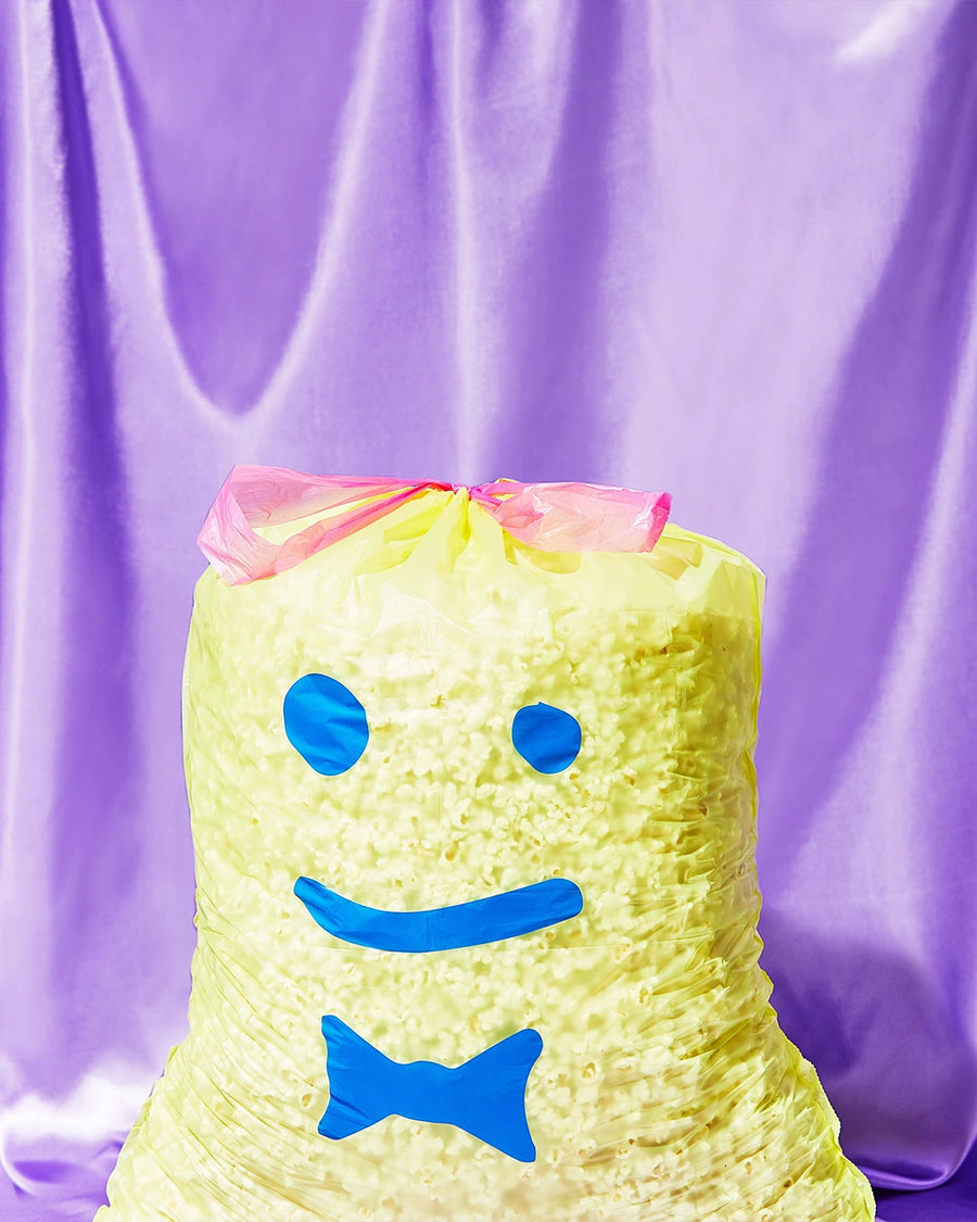 yellow trash bags with blue smiley face print filled with popcorn