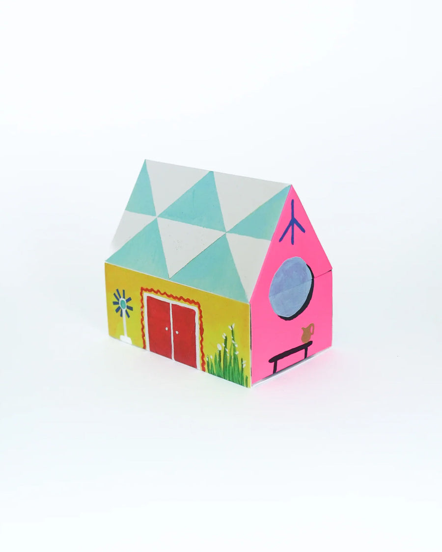 side view of colorful tipped matches in a colorful house shaped box