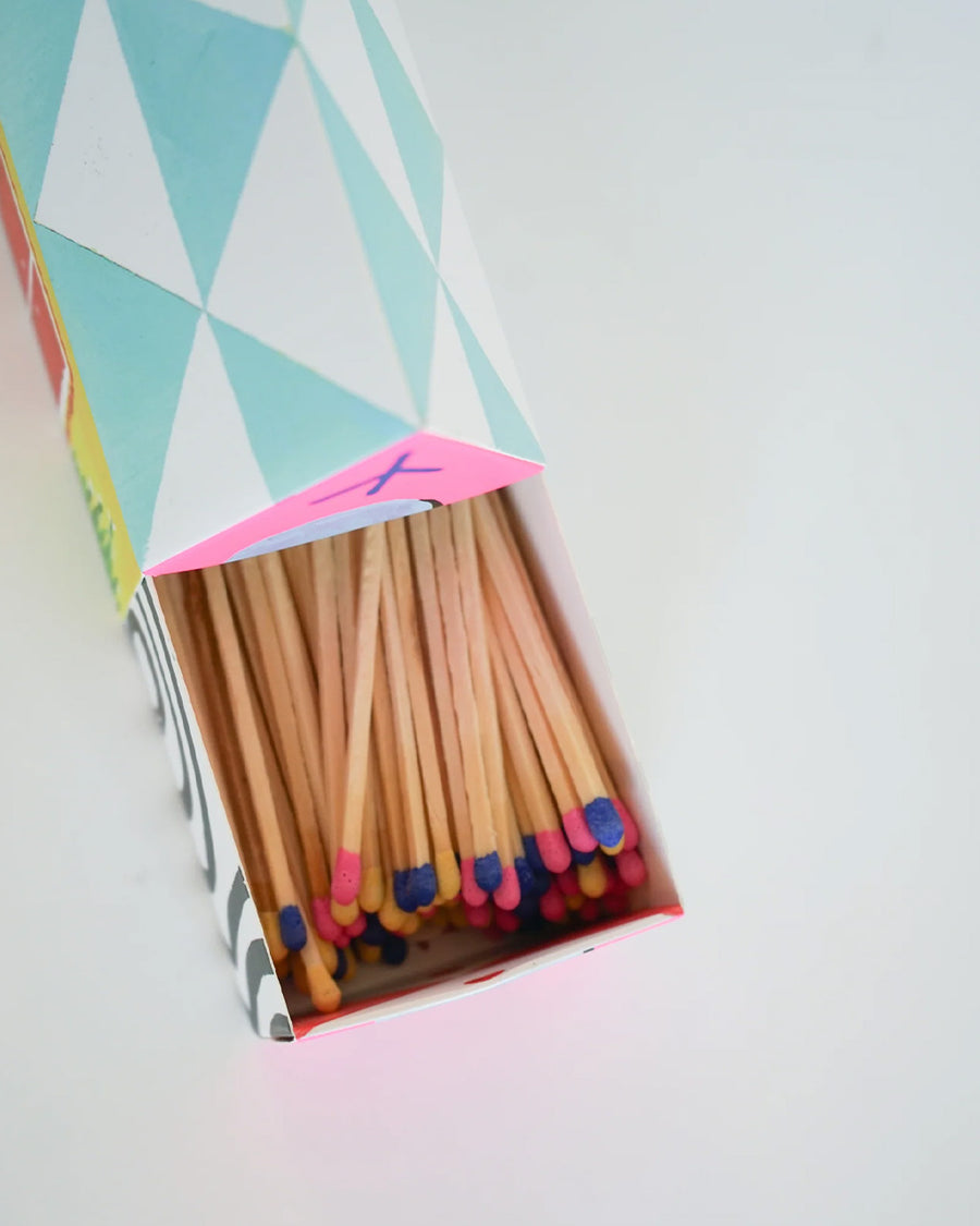 top view of colorful tipped matches in a colorful house shaped box