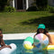 model holding pastel yellow, blue, green, pink, and orange striped beach ball