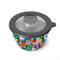 top view of green salad bowl set with colorful 'paper cut out' shapes and smaller container for dressing