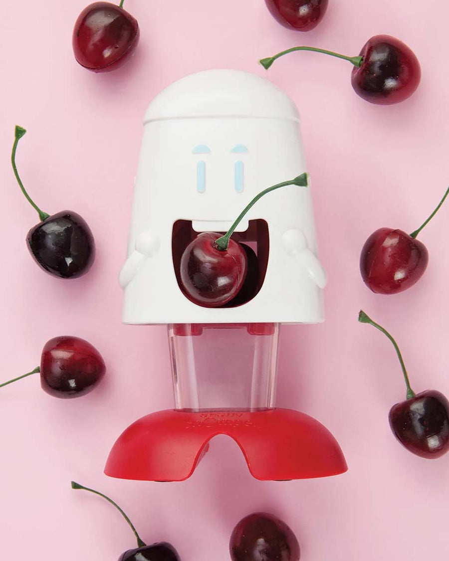 cherry chomper cherry pitter with cartoon face and surrounded by cherries