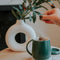 model putting tea bag in dark green smart heated mug set with heat plate