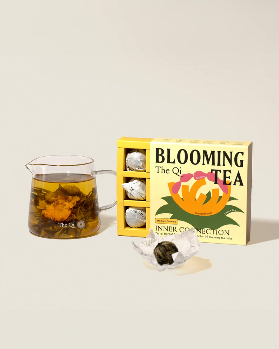 the qi bloom tea in inner connection with a brewed cup next to it