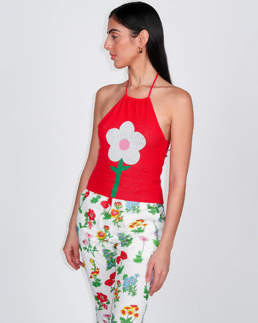 model wearing red knit halter top with white flower print on the front