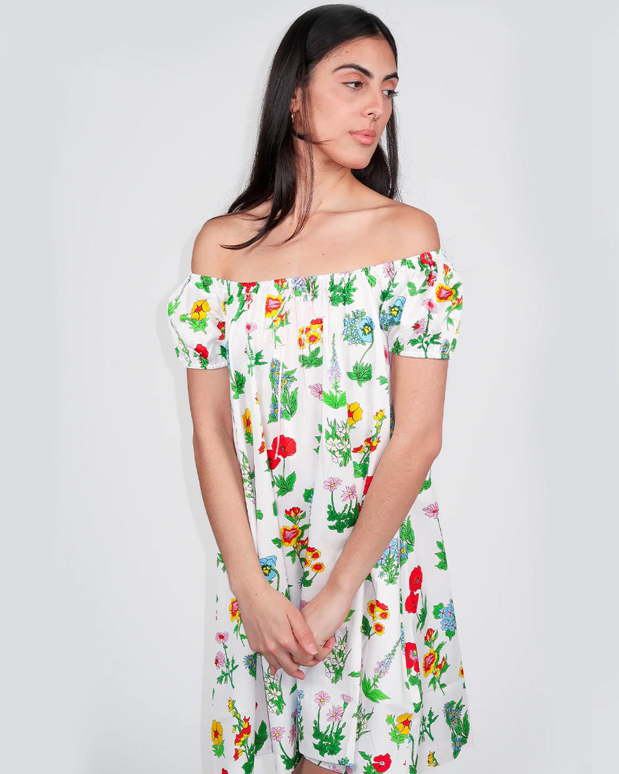 model wearing white mini dress with flowy skirt and colorful floral print