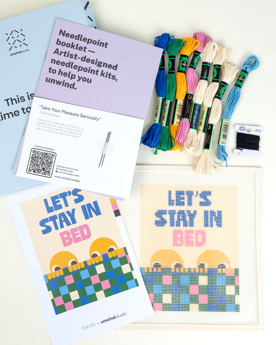 top view of 'let's stay in bed' typography and people graphic needlepoint kit with embroidery yarn and instructions